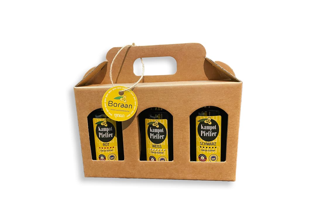 Offener Geschenkträger aus Kraftpapier mit drei Pfefferflaschen, verschnürt mit einem Boraan-Anhänger
